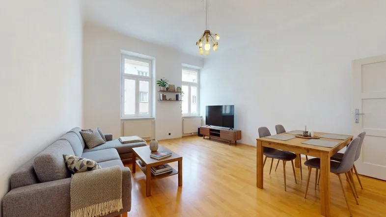 Heller Wohn- und Essbereich mit Holzboden, großen Fenstern und moderner Einrichtung.