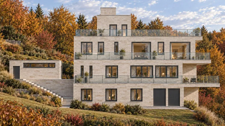 Moderne Villa mit heller Steinfassade, großen Fenstern und mehreren Balkonen in herbstlicher Umgebung.