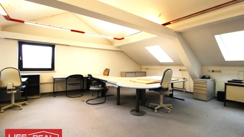 Geräumiges Büro im Dachgeschoss mit Schreibtischen, Bürostühlen und Dachfenstern, ideal für Arbeitsbereiche.