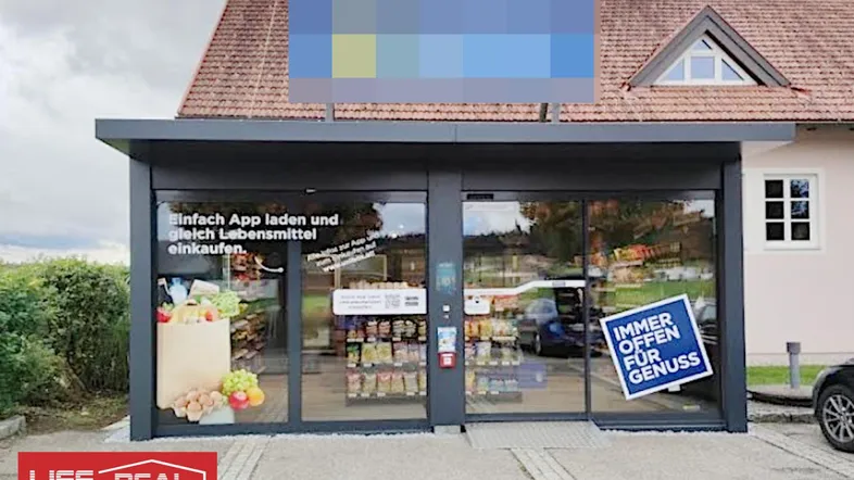 Modernes Selbstbedienungsgeschäft mit großen Glasfronten und einem Werbeschild über dem Eingangsbereich.