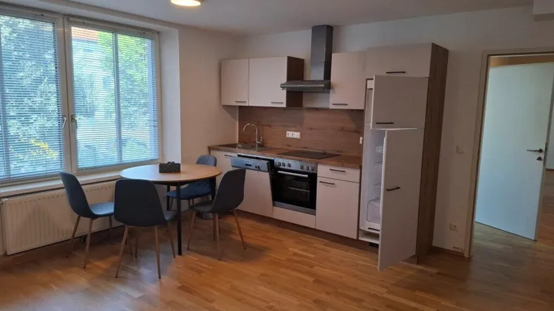 Moderne Einbauküche mit Essbereich, Holzfußboden und großem Fenster für viel Tageslicht.