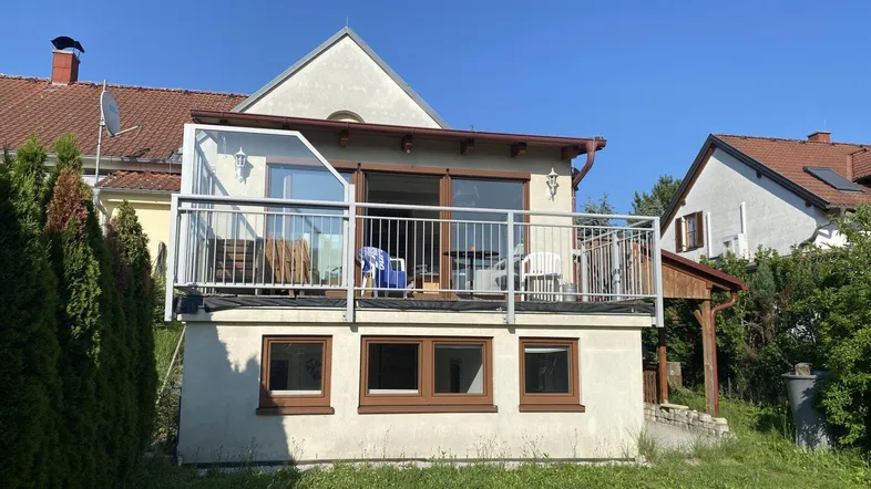 Rückansicht des Hauses mit einem sonnigen Balkon und Blick auf den Gartenbereich.
