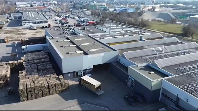Luftaufnahme eines großen Gewerbekomplexes mit Flachdächern, Laderampen und Lagerflächen.