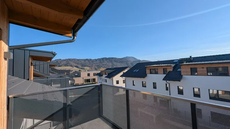 Moderner Balkon mit Metallgeländer und weitem Blick auf die umliegende Berglandschaft.