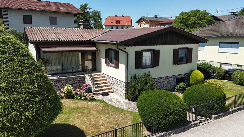 Ansicht des Einfamilienhauses von vorne mit gepflegtem Vorgarten und Steintreppe zum Eingang.