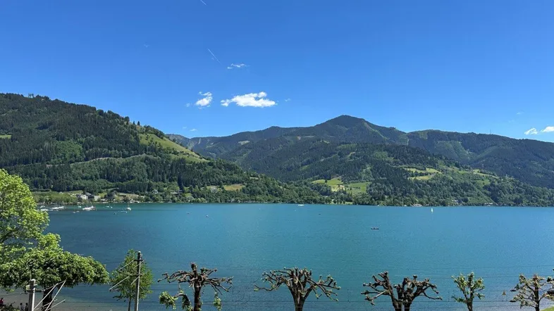 Panoramablick auf den glitzernden See und die majestätischen Berge unter strahlend blauem Himmel.