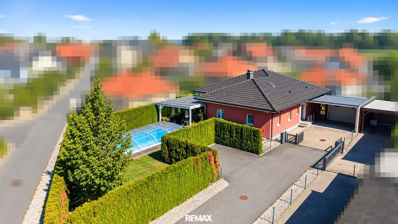 Luftaufnahme eines Einfamilienhauses mit Garten, Pool und gepflegter Hecke in ländlicher Umgebung.