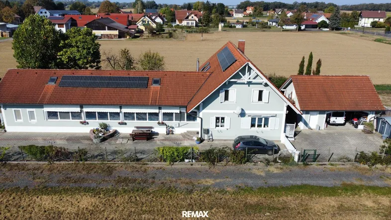 Luftaufnahme des Anwesens mit Photovoltaikanlage auf den Dächern und ländlicher Umgebung.
