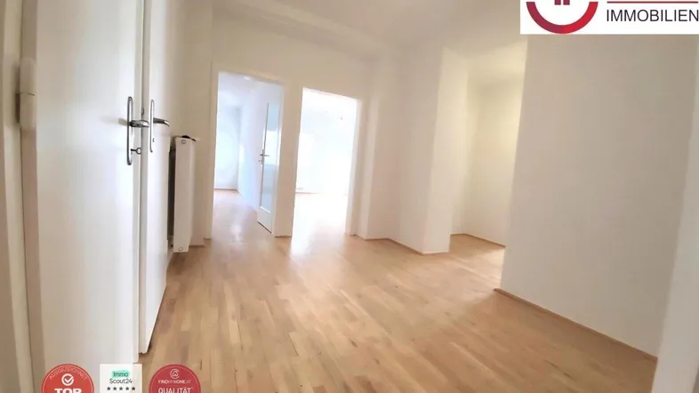 Geräumiges Zimmer mit hellem Parkettboden und Zugang zu weiteren Räumen, ideal für offenes Wohnen.