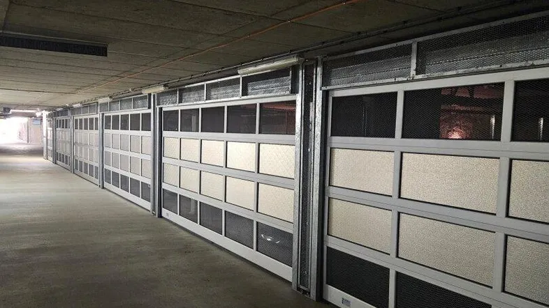 Tiefgarage mit einer Reihe von individuellen Garagenboxen und Betonwänden.