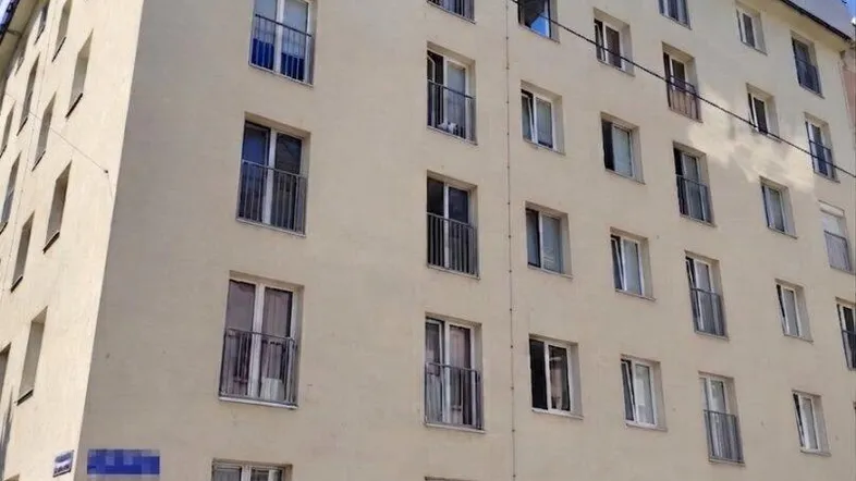Mehrstöckiges Wohngebäude mit heller Fassade und vielen Fenstern in städtischer Umgebung.