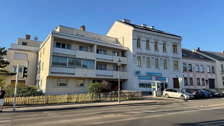 Gebäudeansicht mit einer Mischung aus moderner und klassischer Architektur entlang der Straße.