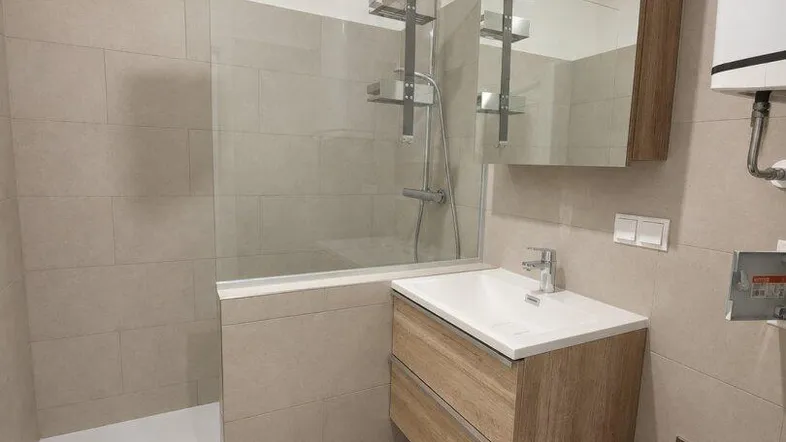 Modernes Badezimmer mit begehbarer Dusche, Holzwaschtischunterschrank und großem Spiegelschrank.