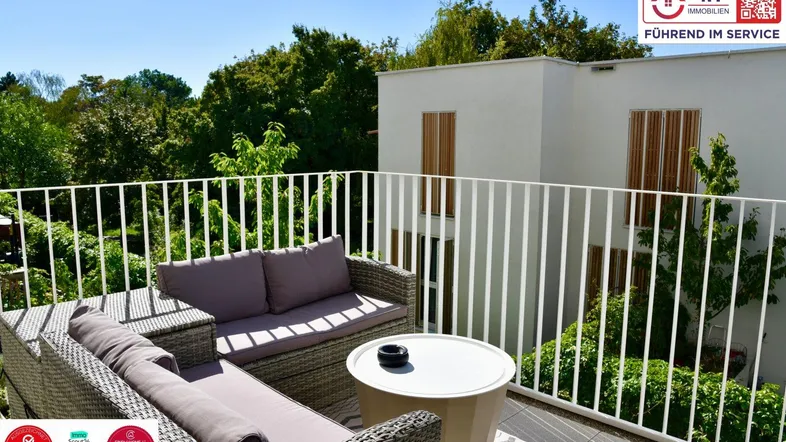 Geräumiger Balkon mit bequemen Outdoor-Möbeln und Blick ins Grüne, ideal zum Entspannen im Freien.