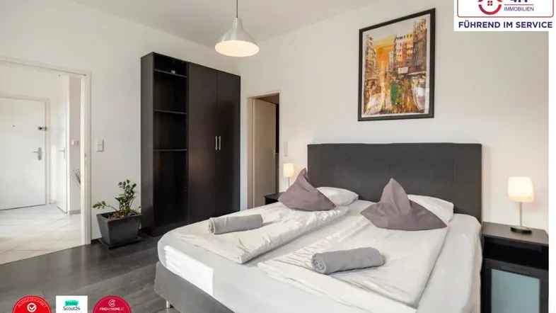 Helles Schlafzimmer mit Doppelbett, dunklem Kleiderschrank und Zugang zu einem weiteren Raum.