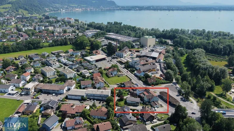 Luftaufnahme der Ortschaft mit See- und Bergblick, das Grundstück ist rot markiert.