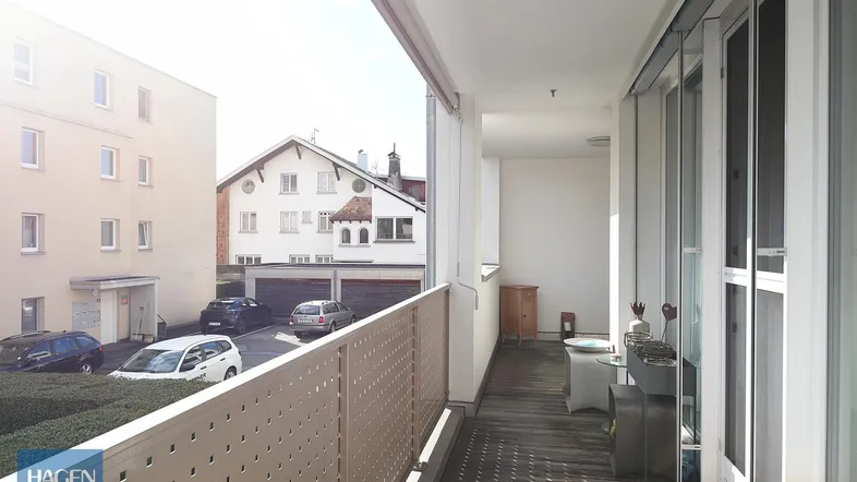 Geräumiger Balkon mit Holzboden, Sitzgelegenheiten und Blick auf die Umgebung.