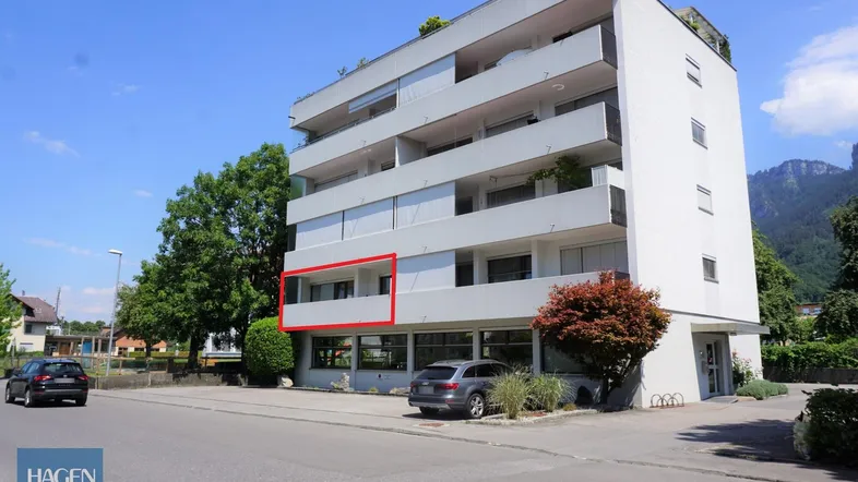 Mehrstöckiges Wohngebäude mit Balkonen und Blick auf die umliegende Berglandschaft.