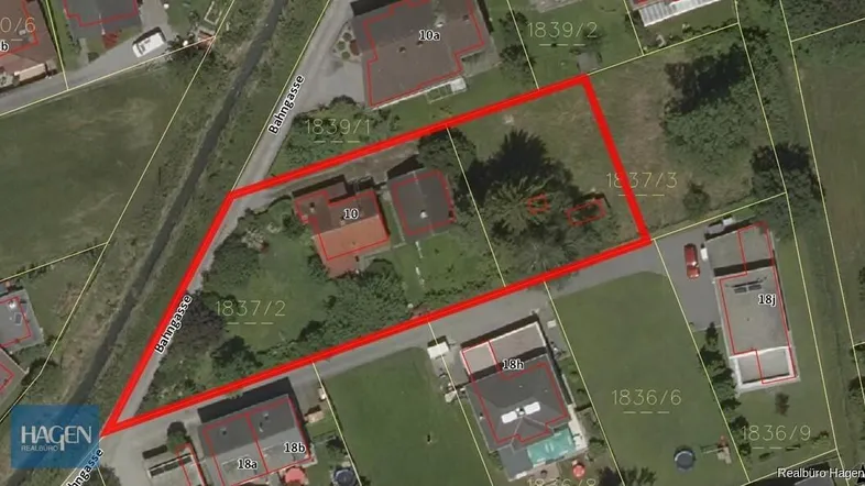 Übersichtliche Luftaufnahme eines Grundstücks mit umliegender Wohnbebauung und Straße, deutlich rot umrandet.