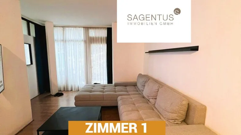 Helles Wohnzimmer mit beigem Ecksofa, dunklem Couchtisch und großen Fenstern.