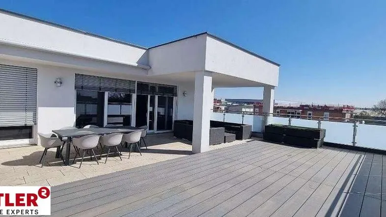 Große, moderne Terrasse mit Holzoptik-Boden, Essbereich und Lounge-Möbeln unter blauem Himmel.