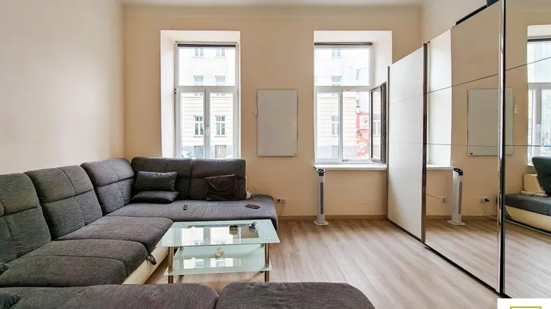 Helles Wohnzimmer mit großem Ecksofa, Couchtisch und Spiegelschränken, die den Raum optisch vergrößern.