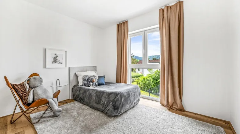 Gemütliches Schlafzimmer mit Holzboden, großem Fenster und Blick auf die Landschaft.