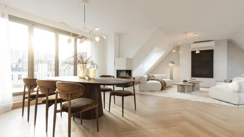 Heller, offener Wohn- und Essbereich mit modernem Design, Fischgrätparkett, Kamin und großen Fenstern.