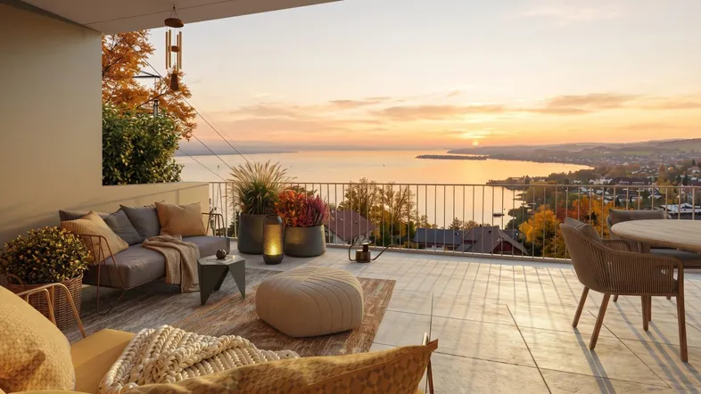 Geräumige Terrasse mit bequemen Loungemöbeln und atemberaubendem Blick auf den See bei Sonnenuntergang.