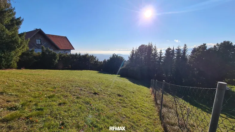 Großes Grundstück mit Haus, weitem Blick über die Landschaft und sonnigem Himmel.
