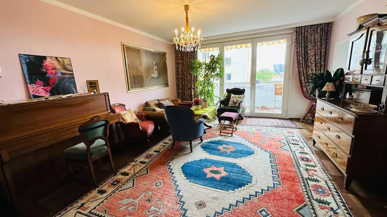 Geräumiges Wohnzimmer mit Klavier, traditionellen Möbeln und Zugang zum Balkon.