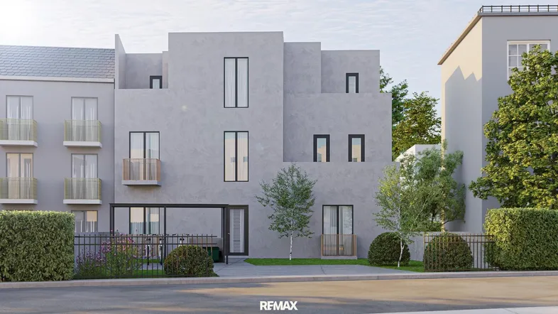 Moderne Fassade eines Mehrfamilienhauses mit klaren Linien und großen Fenstern.