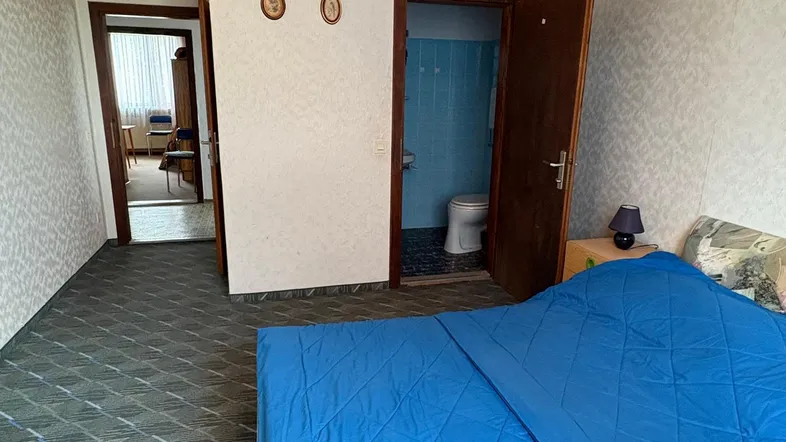 Schlafzimmer mit Teppichboden, Holzdecke und Zugang zu einem Badezimmer.