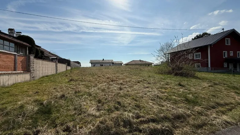 Sonniges Baugrundstück mit leichter Hanglage und Blick auf die umliegende Wohnbebauung.