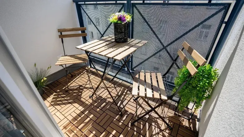Gemütlicher Balkon mit Holzbodenfliesen und Sitzgelegenheiten für entspannte Stunden im Freien.