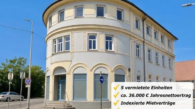 Historisches Eckgebäude mit heller Fassade und großen Fenstern in zentraler Lage.