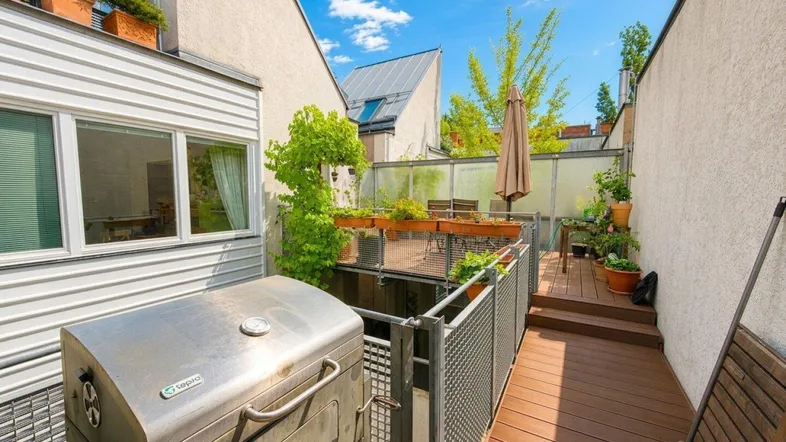 Geräumige Terrasse mit Grillbereich und Holzdeck, ideal für entspannte Stunden im Freien.