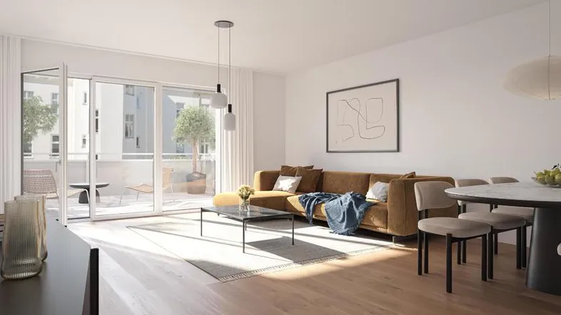 Helles Wohn- und Esszimmer mit Holzboden, modernem Sofa und Zugang zum Balkon.