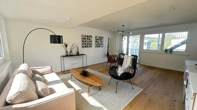 Helles, offenes Wohn-Esszimmer mit Holzboden und moderner Einrichtung.