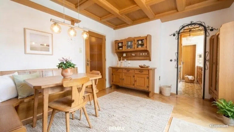 Gemütlicher Essbereich mit Holztisch, Eckbank und rustikaler Holzbalkendecke.