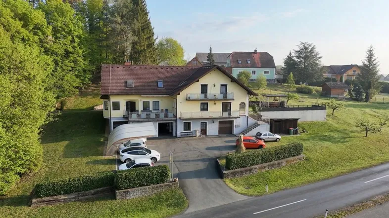 Luftaufnahme des Anwesens mit großem Grundstück, umgeben von grünen Hügeln und Bäumen.