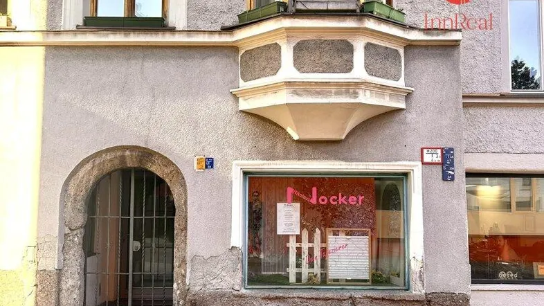 Fassade eines Altbaus mit einem Ladengeschäft im Erdgeschoss und einem markanten Erker.