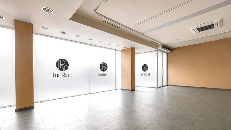 Geräumiges, leeres Büro mit modernen Fliesenböden, abgehängter Decke und integrierter Beleuchtung.