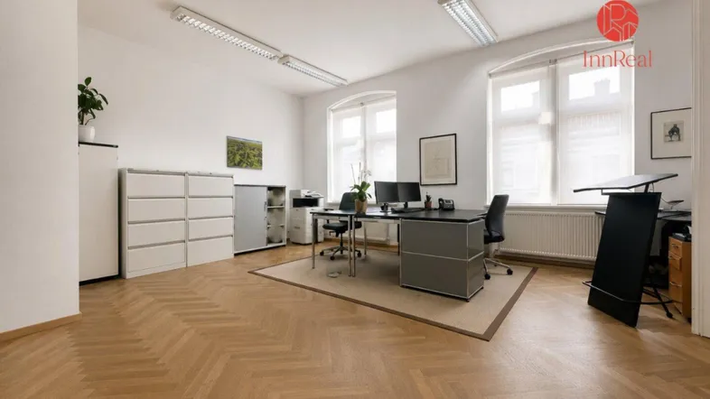 Helles und geräumiges Büro mit Fischgrätparkett, großen Fenstern und moderner Büroeinrichtung.