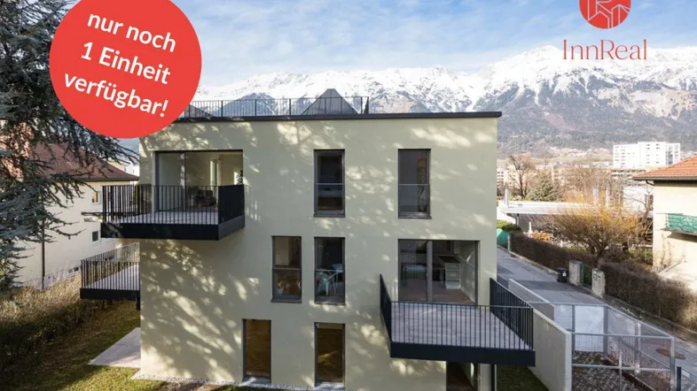 Modernes Neubaugebäude mit mehreren Balkonen und beeindruckendem Blick auf die schneebedeckten Berge.