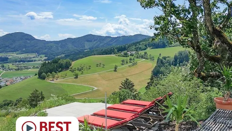 Große Terrasse mit bequemen Liegestühlen bietet einen atemberaubenden Blick auf die umliegende Berglandschaft.