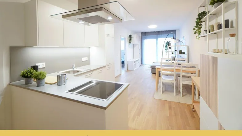 Moderne offene Wohnküche mit hellem Parkettboden und integriertem Essbereich, ideal für geselliges Beisammensein.