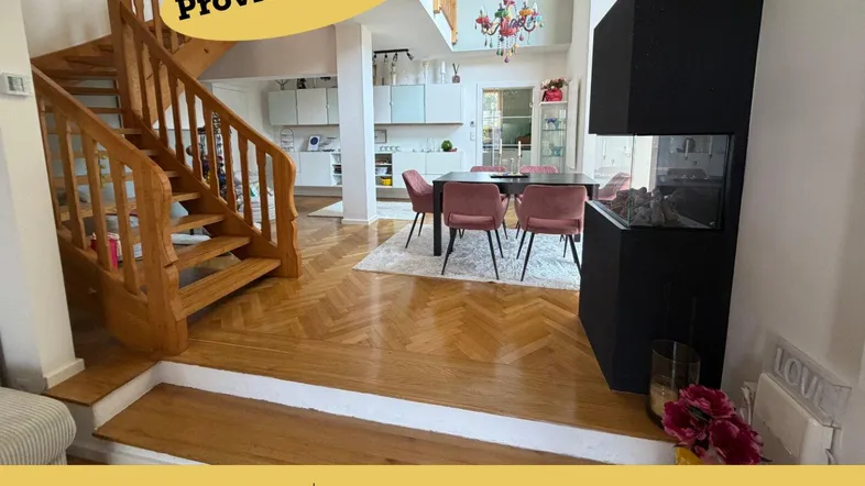Offener Wohnbereich mit eleganter Holztreppe, modernem Kamin und Essbereich mit Parkettboden.