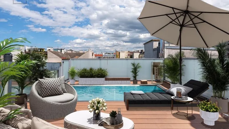 Luxuriöse Dachterrasse mit Pool, bequemen Lounge-Möbeln und weitem Blick über die Stadt.