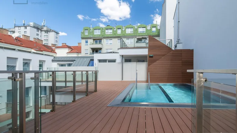 Große Dachterrasse mit integriertem Pool und Holzbelag, umgeben von städtischer Architektur.